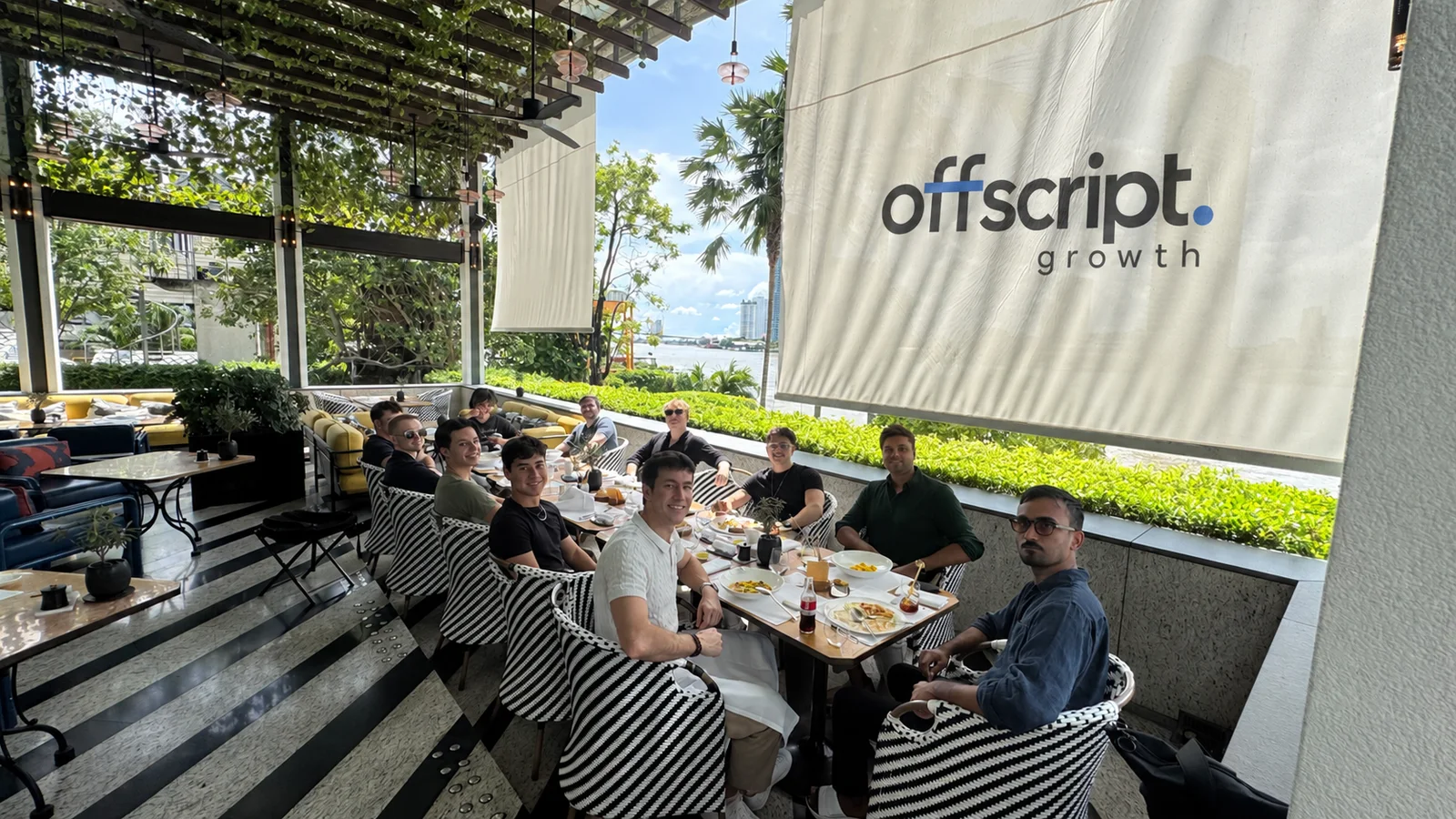 Raytech team gathered around a table with an edited Offscript backdrop